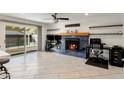 Bright living room with a cozy fireplace, tile flooring, and sliding glass doors to the patio at 2327 E Pebble Beach Dr, Tempe, AZ 85282
