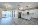 Open-concept kitchen and living area featuring white cabinets, stainless steel appliances, and modern pendant lighting at 3128 E Cheryl Dr, Phoenix, AZ 85028