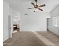 A spacious main bedroom with a ceiling fan, carpet floors, and natural light at 3732 E South Fork Dr, Phoenix, AZ 85044
