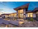 Inviting front entrance with a stone facade, modern lighting, and desert landscaping at 3744 N Rock Wren Ct, Buckeye, AZ 85396