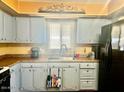 Quaint kitchen featuring light blue cabinets, laminate countertops, and black appliances at 4065 E University Dr # 271, Mesa, AZ 85205