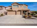 Two-story house featuring a two-car garage, neutral stucco, stone accents and long concrete driveway at 5110 W Sweet Iron Pass, Phoenix, AZ 85083