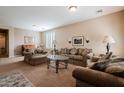 Cozy living room with plush sofas, a glass coffee table, neutral carpet, lamps and shuttered windows at 5110 W Sweet Iron Pass, Phoenix, AZ 85083