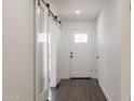 Bright hallway with wood floors and a glass sliding barn door on the left at 743 E Holmes Ave, Mesa, AZ 85204