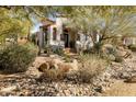Elegant home featuring beautiful desert landscaping, including native plants and stone accents, enhancing its curb appeal at 9370 E Calle De Las Brisas --, Scottsdale, AZ 85255