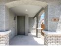 Inviting entryway featuring arched openings, brick columns, and a stylish gray front door with sidelight at 14634 W Sand Hills Rd, Surprise, AZ 85387