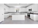 Bright kitchen features white cabinets, granite countertops, stainless steel appliances, and center island at 14634 W Sand Hills Rd, Surprise, AZ 85387