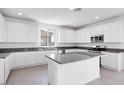 Bright kitchen features white cabinets, granite countertops, stainless steel appliances, and center island at 14634 W Sand Hills Rd, Surprise, AZ 85387