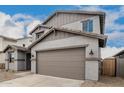 The two-story home boasts a two car garage and architectural details, and desert landscaping at 18433 W Monte Lindo Ln, Surprise, AZ 85387