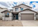Two-story home boasts a neutral color scheme, two car garage, and desert landscaping at 18433 W Monte Lindo Ln, Surprise, AZ 85387