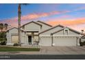 Charming single-story home featuring a two car garage, mature landscaping, and a colorful sunset at 2032 E Sierra Madre Ave, Gilbert, AZ 85296