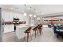 Open-concept kitchen featuring quartz island, stainless appliances, and seamless flow to the dining and living areas at 20365 W Brittlewood Ave, Buckeye, AZ 85396