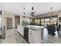 Spacious kitchen island with stainless steel appliances, granite countertops, and seamless flow to the dining area at 2066 N Canelo Hls, Mesa, AZ 85207