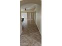Inviting hallway with tiled flooring leads to a bright, open living area with vaulted ceilings and large windows at 23167 W Lasso Ln, Buckeye, AZ 85326