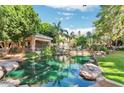 Community area showcasing a lush pond, landscaped grounds, cabana and pool at 2989 N 44Th St # 2007, Phoenix, AZ 85018