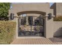 Elegant wrought iron entry gate with stone columns and manicured hedges, leading to a private courtyard at 38820 N 10Th St, Phoenix, AZ 85086
