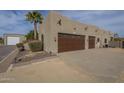 Oversized three-car garage provides ample parking and storage, set against a backdrop of desert landscaping and blue skies at 38820 N 10Th St, Phoenix, AZ 85086