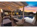 Serene backyard with a pool, spa, and pergola illuminated by string lights at 3930 E Enrose St, Mesa, AZ 85205