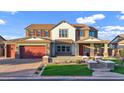 Charming two-story home featuring a brick driveway, vibrant lawn, and a welcoming front porch at 3930 E Enrose St, Mesa, AZ 85205