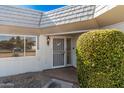 Inviting front entrance with a security screen door and established landscaping at 10419 W Loma Blanca Dr, Sun City, AZ 85351