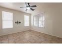 Bright living room featuring a ceiling fan, tiled floor, and a mounted TV bracket at 1088 S Storment Ln, Gilbert, AZ 85296