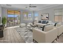 Bright living room features recessed lights, gray accent rug and decor and sliding glass doors at 12121 W Desert Moon Way, Peoria, AZ 85383