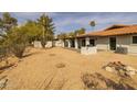 Expansive backyard with desert landscaping, covered patio, white brick outdoor grill, and a fire pit at 16414 N Dixie Mine Trl, Fountain Hills, AZ 85268