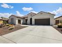 Inviting single-story home featuring desert landscaping and a spacious driveway, offering curb appeal at 16949 W La Reata Ave, Goodyear, AZ 85395