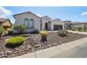Attractive single-story home with desert landscaping including rocks, cacti, and palm trees at 16949 W La Reata Ave, Goodyear, AZ 85395