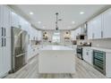 Modern kitchen with white cabinets, stainless steel appliances, gray backsplash, and a large center island at 2022 N 22Nd Pl, Phoenix, AZ 85006