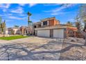 Inviting two-story home showcasing a spacious driveway, three car garage, stone accents and lush green lawn at 20709 N 59Th Dr, Glendale, AZ 85308