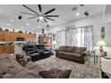 Open-concept living area featuring plush sofas, a large ceiling fan, and an open flow to the kitchen at 2514 E Espada Trl, Casa Grande, AZ 85194