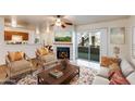 Inviting living room featuring a fireplace, ceiling fan, and sliding glass doors to the outdoor area at 2910 W Marconi Ave # 105, Phoenix, AZ 85053