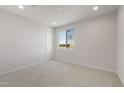 Bright bedroom with neutral carpet, white walls, and a window offering natural light and views at 42850 W Palo Abeto Dr, Maricopa, AZ 85138