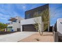 Contemporary home with a dark garage door and desert landscaping, framed by a clear blue sky at 4514 N 8Th Pl, Phoenix, AZ 85014