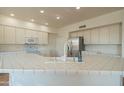 Bright kitchen features white cabinetry, tile countertops, and stainless steel appliances at 7415 W Via De Luna Dr, Glendale, AZ 85310