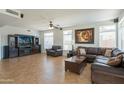 Spacious living room with tile flooring, fireplace, and comfortable leather furniture at 7415 W Via De Luna Dr, Glendale, AZ 85310