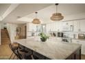 Bright kitchen featuring a large marble island, white cabinets, and modern pendant lighting at 8740 E Mulberry St, Scottsdale, AZ 85251