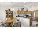 Eat-in kitchen featuring wood cabinetry, stainless steel appliances, and a breakfast bar at 11408 E Natal Ave, Mesa, AZ 85209