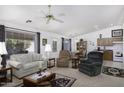 Inviting living room with comfortable seating, a ceiling fan, and a view into the dining area and kitchen at 11408 E Natal Ave, Mesa, AZ 85209