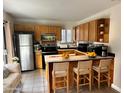 Functional kitchen features a stainless steel refrigerator, tile floors, breakfast bar, and ample cabinet space at 15650 N 19Th Ave # 1189, Phoenix, AZ 85023