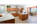 Bright kitchen with wooden cabinetry, modern appliances, and a breakfast nook at 16935 W Desert Blossom Way, Surprise, AZ 85387