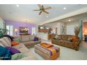 Spacious living room with neutral decor, comfortable seating, and a ceiling fan at 16935 W Desert Blossom Way, Surprise, AZ 85387