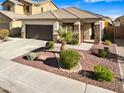 Eye-level image of a well-maintained home with desert landscaping and a spacious driveway at 17193 N Rosemont St, Maricopa, AZ 85138