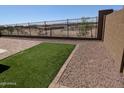 Well kept backyard with gravel, brick, and small patch of artificial turf at 20407 W Calle Encorvada --, Buckeye, AZ 85396