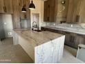 Beautiful kitchen featuring a waterfall island, custom cabinetry, marble countertops, and modern fixtures at 29022 N 166Th Ave, Surprise, AZ 85387