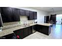 This kitchen features dark wood cabinets, granite countertops, stainless steel dishwasher, and a mosaic backsplash at 3113 E Danbury Rd # 5, Phoenix, AZ 85032