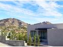 Modern home's exterior showcasing clean lines, complemented by the Arizona landscape and blue sky at 4232 E Upper Ridge Way, Paradise Valley, AZ 85253