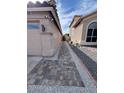 Side yard featuring a walkway made of square pavers, gravel accents, and home security system at 4435 E Badger Way, Phoenix, AZ 85044