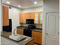 A modern kitchen featuring wood cabinets, granite countertops, and stainless steel appliances and a breakfast bar at 6900 E Princess Dr # 1229, Phoenix, AZ 85054